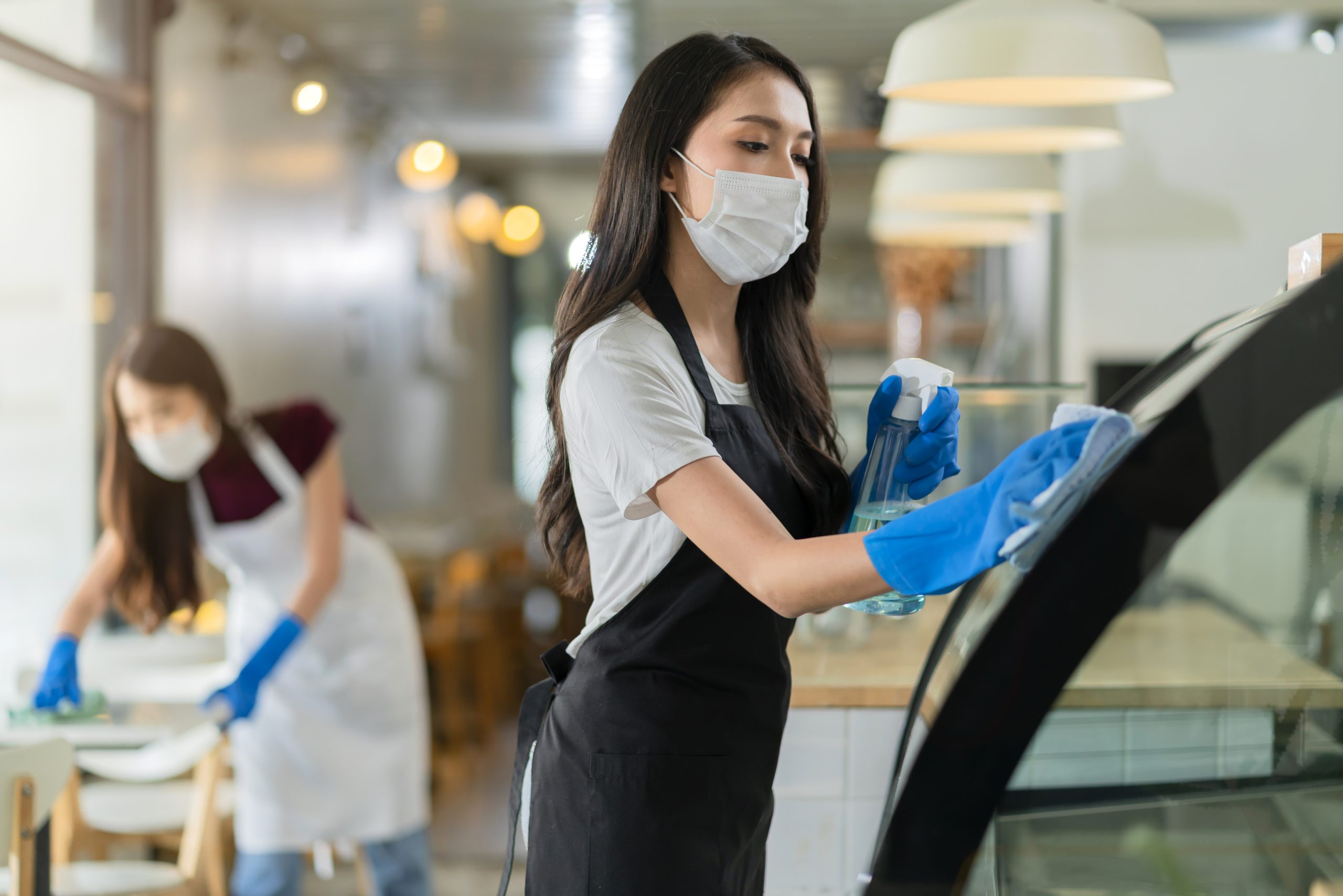 attractive-positive-young-asian-woman-staff-uniform-apron-spraying-detergent-alcohol-counter-product-cabinet-wiping-it-with-soft-cloth-when-disinfecting-cafe-ther-morning-safe-clean