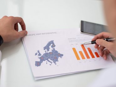 Close-up of male hands working with Europe sale statistic report Close-up of male hands working with Europe sale statistic report